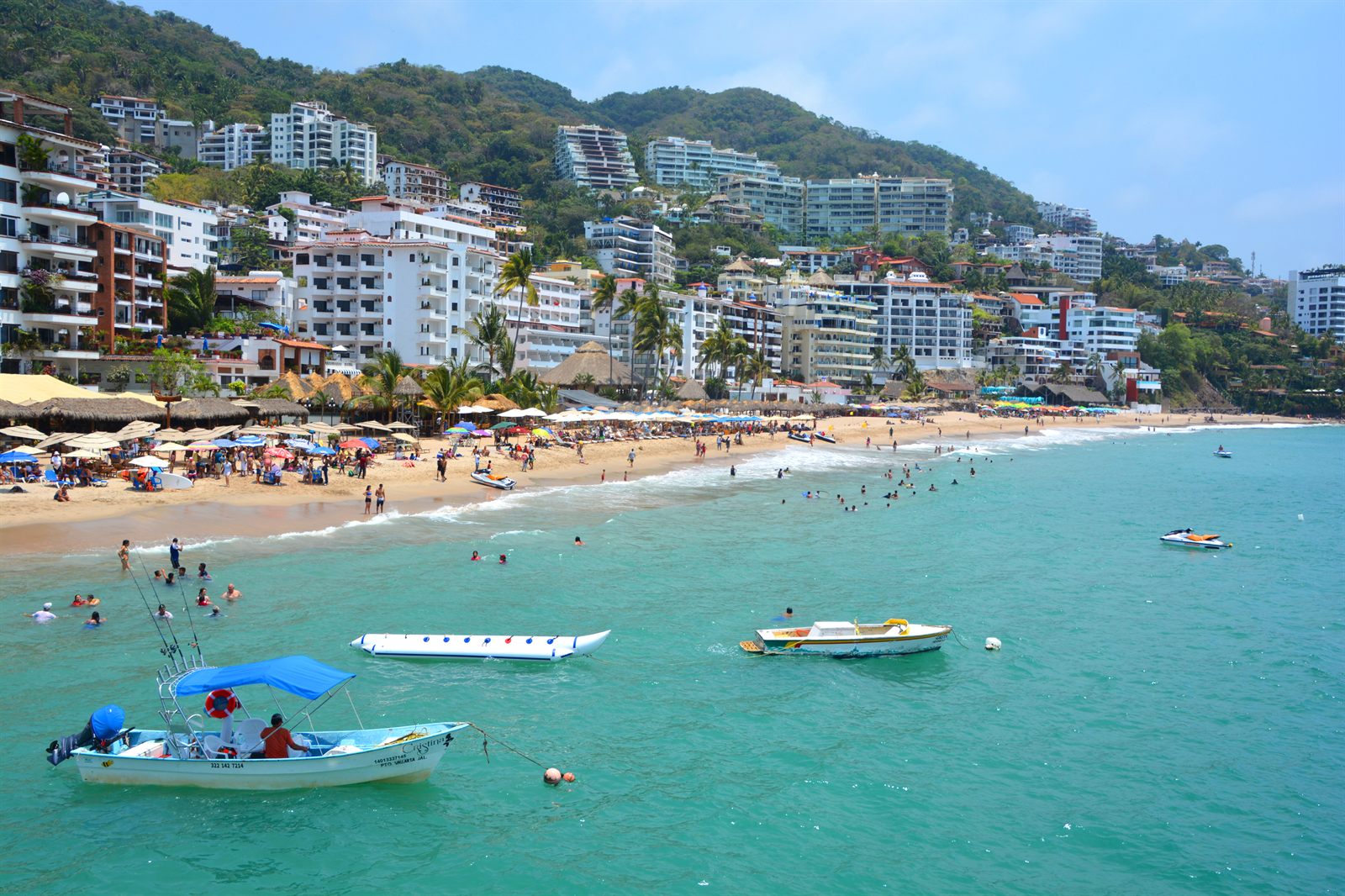 Beach, small boats and hillside hotels on the Pacific coast at Puerto Vallarta