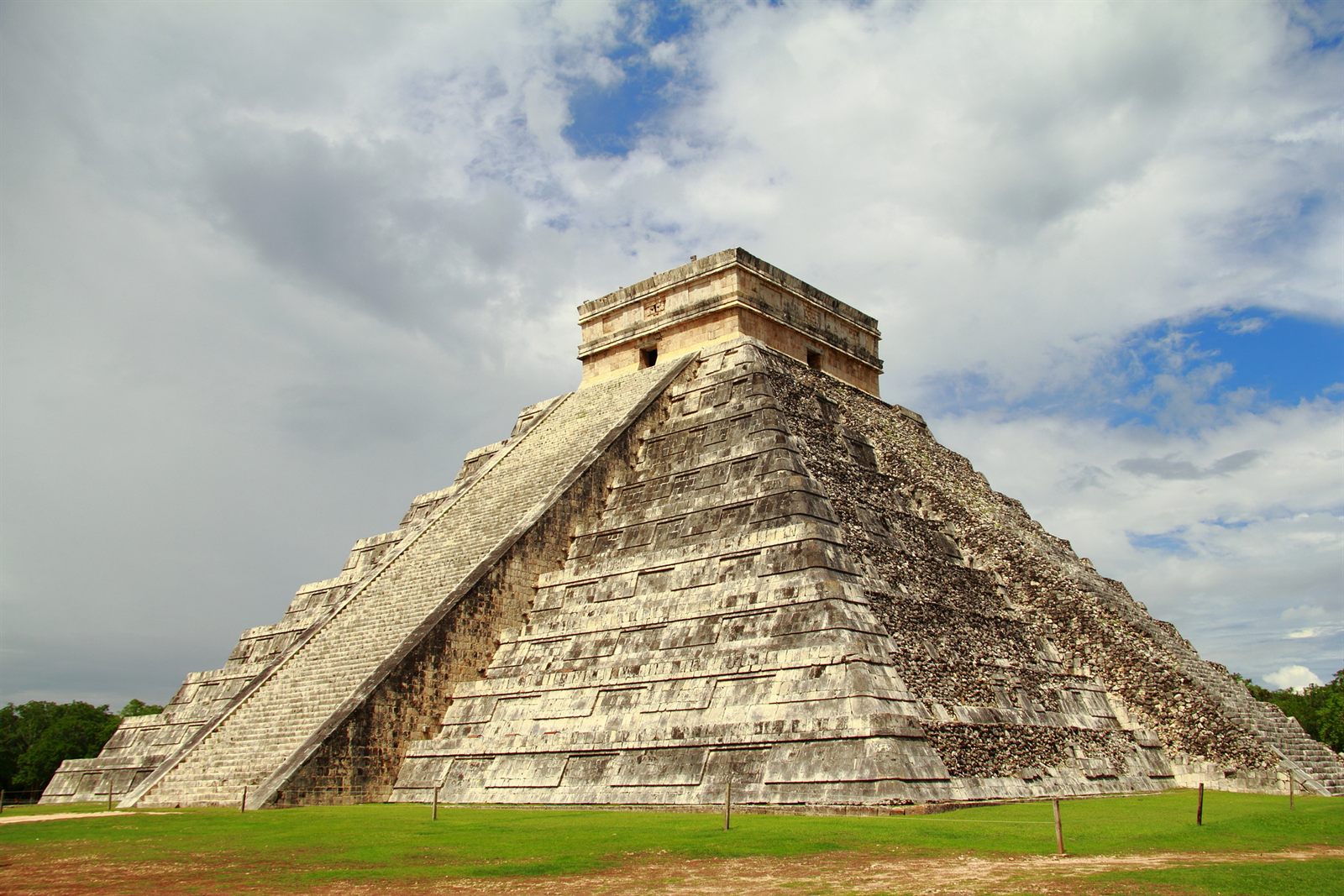 The stepped pyramid of El Castillo at Chichen Itza under a cloudy sky